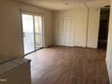 View of a living room with worn wood floors, sliding patio doors, and a closet at 4032 Chaucer Dr, Durham, NC 27705