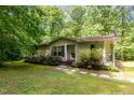 Inviting single-story home surrounded by lush greenery, offering a serene setting at 441 Wintergreen Rd, Timberlake, NC 27583