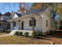 Side angle of a house with a cozy front porch, complemented by lush landscaping and mature trees at 704 Pender St, Rocky Mount, NC 27801