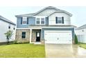 Charming two-story home featuring blue siding, brick, a black front door, and an attached two-car garage at 768 Riguard Way, Wendell, NC 27591