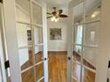 Dining room with hardwood floors, white trim, and a ceiling fan chandelier visible through glass doors at 7721 Sutcliffe Dr, Raleigh, NC 27613