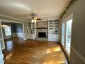 Spacious living room features hardwood floors, built-in shelving, and a cozy fireplace, perfect for relaxing at 7721 Sutcliffe Dr, Raleigh, NC 27613