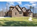 Elegant stone and brick home with a two car garage and a curved walking path at 7936 Nc 42, Holly Springs, NC 27540