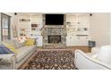 Comfortable living room with stone fireplace, built in shelving, and hardwood floors at 7936 Nc 42, Holly Springs, NC 27540