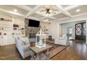 Inviting living room with coffered ceiling, stone fireplace, and built in shelving at 7936 Nc 42, Holly Springs, NC 27540