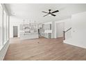 Bright, open-concept living space with modern kitchen, hardwood floors, and stylish ceiling fan at 9173 Dupree Meadow Ct # 25, Angier, NC 27501