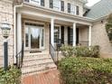 Inviting front porch with classic white columns, a brick walkway, and space for rocking chairs at 101 Hedwig Ct, Cary, NC 27518