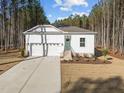 Charming one story home featuring a neutral exterior, attached two car garage, and manicured front yard at 10405 Hamish Dr, Zebulon, NC 27597