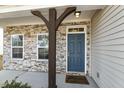 Inviting covered entry with a blue front door, supported by a decorative wooden post at 105 Hanover Ct, Clayton, NC 27527