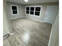 Bright living room featuring hardwood floors, large windows, and a fresh coat of paint, offering a welcoming space at 1128 Horseshoe Rd, Durham, NC 27703