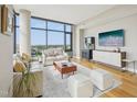 Spacious living room with hardwood flooring, large windows, and a stylish entertainment center at 122 N Harrington St # 1105, Raleigh, NC 27603