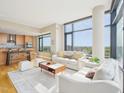 Open concept living room with a modern kitchen, large windows, and comfortable seating area at 122 N Harrington St # 1105, Raleigh, NC 27603