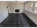 Bright living room with checkerboard floors, fireplace, and large windows allowing natural light at 1269 Manns Chapel Rd, Pittsboro, NC 27312