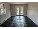 View of the room with checkerboard flooring and double doors leading to the outside at 1269 Manns Chapel Rd, Pittsboro, NC 27312