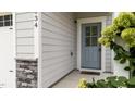 A charming blue front door, complemented by stone accents and lush greenery, welcomes you home at 1634 Brussels Dr, Apex, NC 27502
