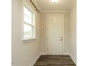 Bright entryway featuring wood flooring and a white door illuminated by natural light from the nearby window at 177 Magenta Rose Dr, Raleigh, NC 27610