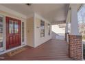 Inviting covered front porch featuring wood flooring, decorative columns, and a red front door at 2006 Mill Gate Ln, Cary, NC 27519