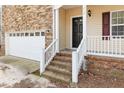 Close up of the front entrance with a charming brick porch and white railings at 202 River Hills Dr, Clayton, NC 27527