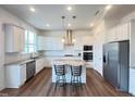 Bright, open kitchen featuring stainless steel appliances, center island seating, and stylish pendant lighting at 208 Acorn Crossing Rd, Holly Springs, NC 27540
