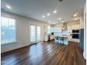 A bright, open kitchen featuring stainless steel appliances, a center island, and hardwood floors at 208 Acorn Crossing Rd, Holly Springs, NC 27540