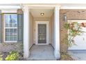 Inviting front porch with brick accents and support columns, complemented by manicured landscaping and neutral colors at 2224 Cedar Grove Dr, Durham, NC 27703