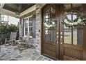 Inviting front porch with rocking chairs and double doors with floral wreaths at 2401 Chianti Ct, Apex, NC 27502