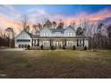 Beautiful two-story home featuring a classic white facade and an inviting covered front porch at 2418 Crossroads Ave, Hillsborough, NC 27278