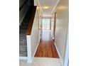 Hallway with hardwood floors leads to patio doors, with carpeted stairs on the left at 250 S Estes S Dr # Apt 113, Chapel Hill, NC 27514