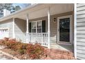 Inviting front porch with white railing, brick steps, and a view of the home's exterior and surrounding landscape at 262 Tillamook Dr, Wake Forest, NC 27587