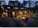 View of backyard featuring a brick patio and fire pit with seating, great for evening gatherings at 2819 Meacham Rd, Chapel Hill, NC 27516