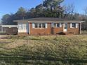 Traditional brick home with light blue shutters featuring a cozy covered porch and a welcoming entrance at 300 Grove St, Oxford, NC 27565