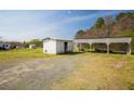 Expansive backyard with a white storage building and covered parking area, perfect for outdoor activities at 300 Grove St, Oxford, NC 27565