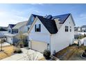 Two-story home with a two-car garage and solar panels adorning the roof, complemented by a well-kept lawn at 305 Chestnut Oaks Pl, Durham, NC 27704