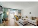 Bright living room with a cozy sofa, desk, and sliding glass doors leading to a balcony at 311 Swift Ave Ave # 202, Durham, NC 27705