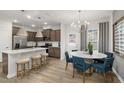 Open concept kitchen and dining area with stainless appliances, granite island, and modern chandelier at 4002 Kidd Pl, Durham, NC 27703