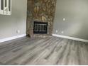 Living room features luxury vinyl flooring and stone fireplace at 4807 Tyne Drive, Durham, NC 27703