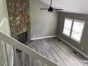 Bright living room features luxury vinyl flooring, stone fireplace, and ceiling fan at 4807 Tyne Drive, Durham, NC 27703
