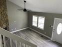 Bright living room features luxury vinyl flooring, stone fireplace, and ceiling fan at 4807 Tyne Drive, Durham, NC 27703