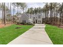 A stately two-story grey house features a curved driveway and well-kept lawn at 49 Bonterra Way, Chapel Hill, NC 27516