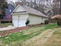This home features a well-maintained yard, an attached two-car garage, and mature trees surrounding the property at 4909 Willow Tree Ln, Clayton, NC 27520