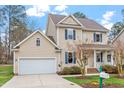 Inviting two-story home with blue shutters, a cozy porch, attached garage and well-kept lawn at 5 Piney Park Ln, Durham, NC 27713