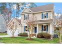 Beautiful two-story home with blue shutters, a welcoming porch, a well-manicured lawn, and an attached garage at 5 Piney Park Ln, Durham, NC 27713