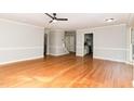 Spacious living area featuring wood floors, neutral paint, and staircase access at 6800 Chamonix Pl, Raleigh, NC 27613