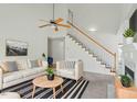 Bright living room featuring a high ceiling, modern decor, and a staircase to the second floor at 7201 Spanglers Spring Way, Raleigh, NC 27610