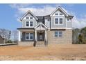 Charming new home with gray siding, brick, and a covered porch, creating a welcoming entrance at 9004 Penny Rd, Raleigh, NC 27606