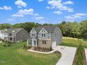 Charming two-story home with gray siding, lush lawn, and a convenient driveway at 9004 Penny Rd, Raleigh, NC 27606