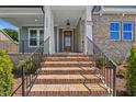 Inviting front entrance with brick steps and a stylish wood door at 9004 Penny Rd, Raleigh, NC 27606