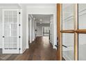 Inviting hallway with hardwood floors and white trim, leading to a bright living area with sliding doors at 9004 Penny Rd, Raleigh, NC 27606