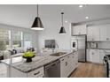 Open-concept kitchen featuring a spacious island with seating and stainless steel appliances, flowing into the living area at 1006 Westerland Way # 198, Durham, NC 27703