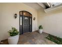 A close-up of a black front door with sidelights and transom window, framed by sconces and planters at 104 Hampshire Pl, Chapel Hill, NC 27516